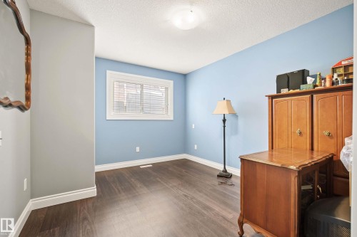 Room featuring wood-finish flooring, light blue and gray wall tones, a window with white trim and blinds, white baseboards, and a flush mount ceiling light fixture - 104 Bayview Drive, Rural Parkland County, AB - Indoor Photo Showing Other Room