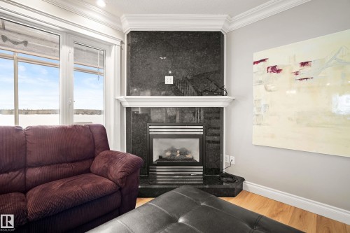 Corner fireplace featuring a dark stone surround and white mantel - 104 Bayview Drive, Rural Parkland County, AB - Indoor Photo Showing Living Room With Fireplace