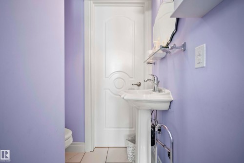 Pedestal sink with chrome faucet, complemented by a wall-mounted mirror and glass shelf - 104 Bayview Drive, Rural Parkland County, AB - Indoor Photo Showing Bathroom