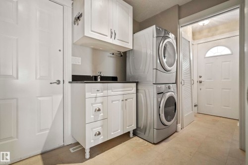 Dedicated laundry area featuring a stacked washer and dryer - 104 Bayview Drive, Rural Parkland County, AB - Indoor Photo Showing Laundry Room