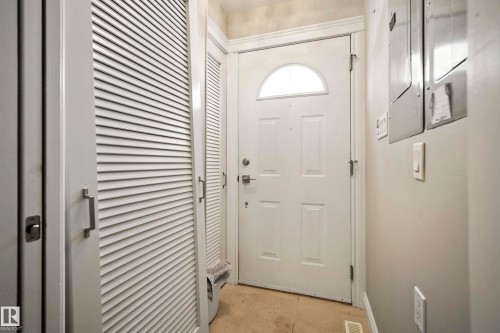 Entryway featuring a white paneled door with an arched transom window, a louvered bi-fold closet door, and light-toned flooring - 104 Bayview Drive, Rural Parkland County, AB - Indoor Photo Showing Other Room