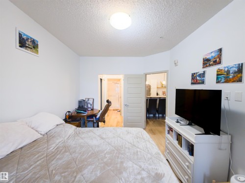 Bright interior space featuring a ceiling-mounted light fixture, light-toned walls, and wood-finish flooring - 135 7825 71 Street, Edmonton, AB - Indoor Photo Showing Bedroom