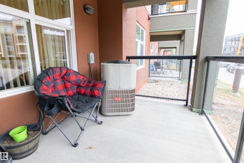 Exterior patio with concrete flooring, glass panel railing, and an exterior wall light fixture - 135 7825 71 Street, Edmonton, AB - Outdoor With Exterior