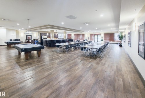 Spacious common room featuring wood-finish flooring, recessed lighting, and a neutral color palette - 135 7825 71 Street, Edmonton, AB - Indoor Photo Showing Other Room