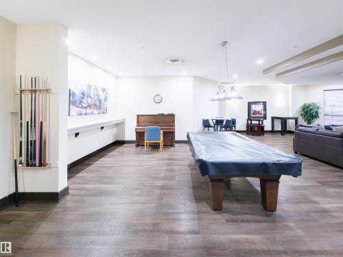 Spacious common room featuring wood-finish flooring, recessed lighting, and a full-size billiard table - 135 7825 71 Street, Edmonton, AB - Indoor Photo Showing Other Room