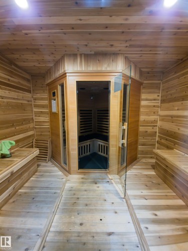 Interior sauna room featuring wood-finish flooring, paneled walls, and built-in benches - 135 7825 71 Street, Edmonton, AB - Indoor Photo Showing Other Room