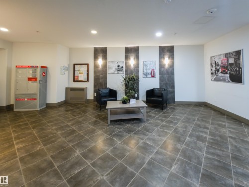 Spacious common area featuring large format tile flooring and white walls - 135 7825 71 Street, Edmonton, AB - Indoor Photo Showing Other Room