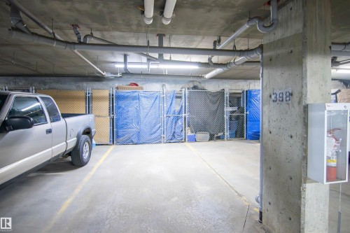 Enclosed parking space with concrete flooring, overhead piping, and fluorescent lighting - 135 7825 71 Street, Edmonton, AB - Indoor Photo Showing Garage