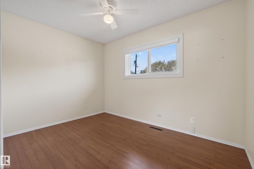 Interior room featuring wood-finish flooring, light-toned walls, and white trim - 12016 51 Street, Edmonton, AB - Indoor Photo Showing Other Room