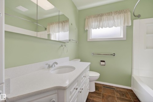 Bathroom featuring a white vanity with an integrated sink, polished chrome faucet, and a large mirrored medicine cabinet - 12016 51 Street, Edmonton, AB - Indoor Photo Showing Bathroom