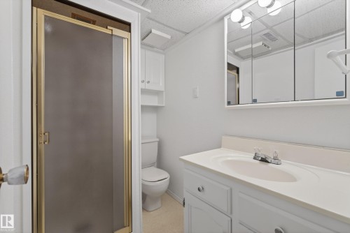 Bathroom vanity with an integrated sink, polished chrome faucet, and mirrored medicine cabinet - 12016 51 Street, Edmonton, AB - Indoor Photo Showing Bathroom