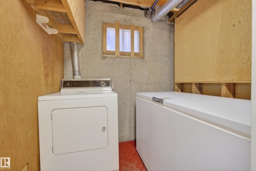 Utility area featuring exposed concrete walls and plywood paneling - 12016 51 Street, Edmonton, AB - Indoor Photo Showing Laundry Room