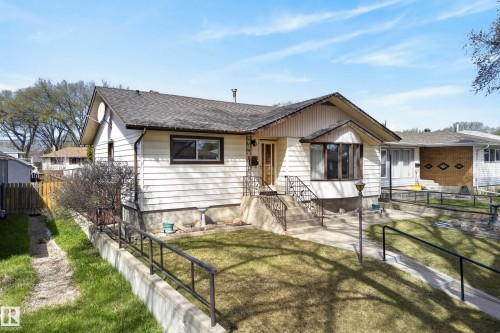 Exterior featuring white siding, a prominent bay window, and a gabled roofline - 12016 51 Street, Edmonton, AB - Outdoor With Deck Patio Veranda