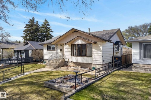 Split-level residence featuring light-colored siding and a dark shingle roof - 12016 51 Street, Edmonton, AB - Outdoor With Deck Patio Veranda