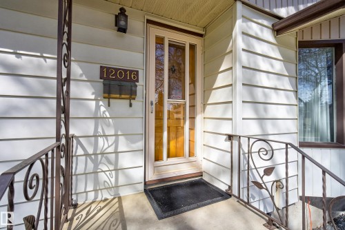 White horizontal siding exterior with a glass-paneled entry door - 12016 51 Street, Edmonton, AB - Indoor Photo Showing Other Room