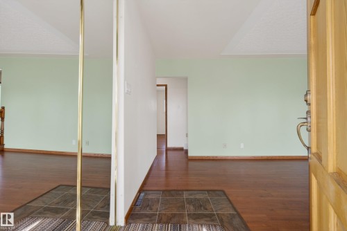 Entryway featuring a wood-finish door with brass hardware, tile flooring, and a mirrored closet door with a brass frame - 12016 51 Street, Edmonton, AB - Indoor Photo Showing Other Room