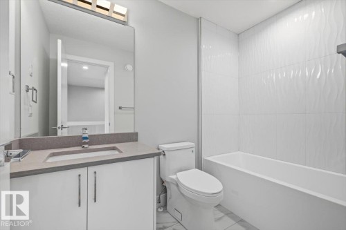 Bathroom featuring a white vanity with a gray countertop, integrated sink, and modern faucet - 9933 79 Street, Edmonton, AB - Indoor Photo Showing Bathroom