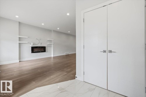 Entryway with a marble-finish tile floor, dual white doors, and brushed nickel hardware - 9933 79 Street, Edmonton, AB - Indoor With Fireplace