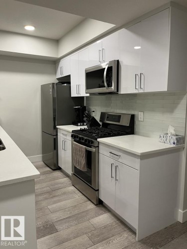 Modern kitchen with white shaker-style cabinetry, stainless steel appliances, and light-toned countertops - 9933 79 Street, Edmonton, AB - Indoor Photo Showing Kitchen