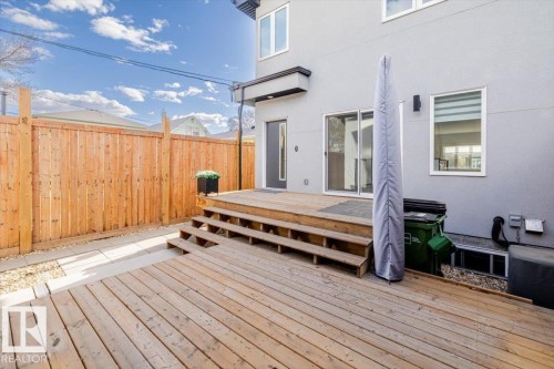 Expansive wood deck with stairs leading to the building's sliding glass doors - 9933 79 Street, Edmonton, AB - Outdoor With Deck Patio Veranda With Exterior