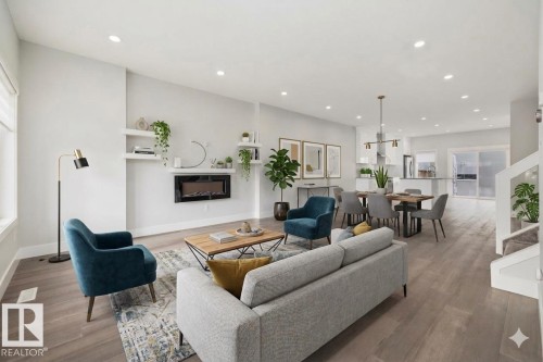 Open-concept living space featuring wood-finish flooring, recessed lighting, and a modern wall-mounted fireplace - 9933 79 Street, Edmonton, AB - Indoor Photo Showing Living Room With Fireplace