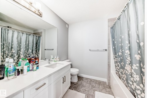 Bathroom featuring a vanity with white cabinetry, a single sink, and a large mirror - 19635 29 Avenue, Edmonton, AB - Indoor Photo Showing Bathroom
