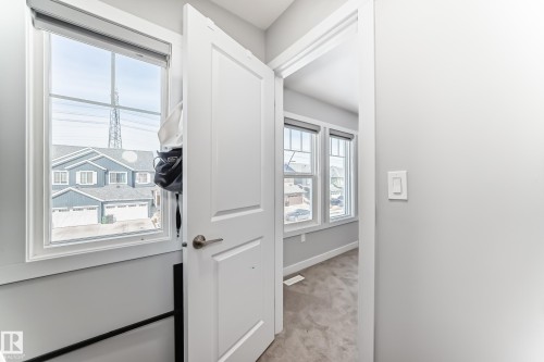 This property features bright interiors with light gray walls, white trim, and a white paneled door - 19635 29 Avenue, Edmonton, AB - Indoor Photo Showing Other Room