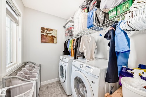 The property offers a dedicated laundry area with a front-loading washing machine, a front-loading dryer, and a window providing natural light - 19635 29 Avenue, Edmonton, AB - Indoor Photo Showing Laundry Room