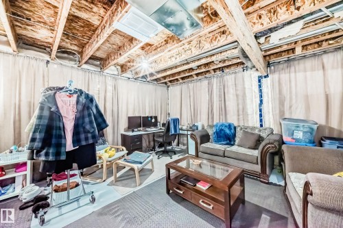 Unfinished basement space with exposed wooden ceiling beams and a concrete floor - 19635 29 Avenue, Edmonton, AB - Indoor Photo Showing Basement