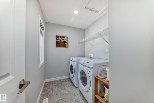 Dedicated laundry area featuring a tiled floor, overhead wire shelving, and a single window - 19635 29 Avenue, Edmonton, AB - Indoor Photo Showing Laundry Room