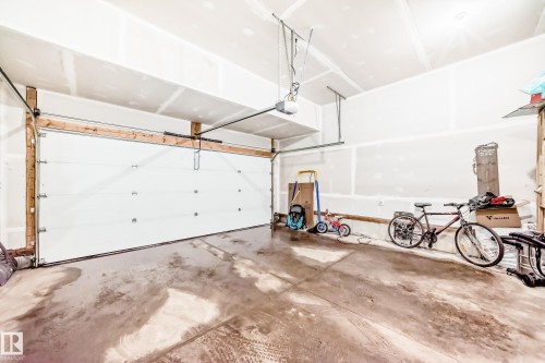 The property features an attached garage with a concrete floor and a white garage door - 19635 29 Avenue, Edmonton, AB - Indoor Photo Showing Garage