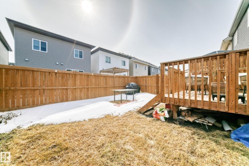 The property features a fenced backyard with a wooden deck, a grassy area, and a section of snow-covered ground - 19635 29 Avenue, Edmonton, AB - Outdoor With Exterior