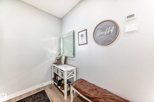 Entryway featuring light-colored walls, light wood flooring, and a decorative mirror - 19635 29 Avenue, Edmonton, AB - Indoor Photo Showing Other Room