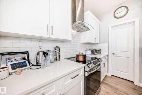 The kitchen features white cabinetry, white subway tile backsplash, and light-colored countertops - 19635 29 Avenue, Edmonton, AB - Indoor Photo Showing Kitchen