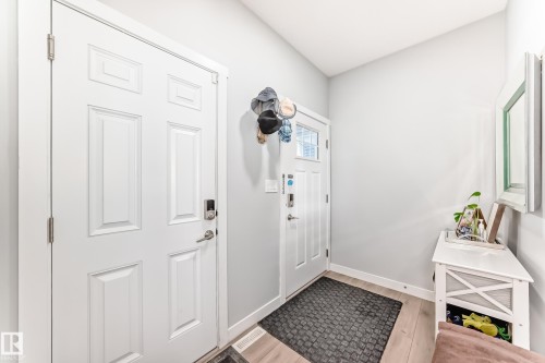 Entryway featuring light-colored walls, a light-toned wooden floor, and two panel doors - 19635 29 Avenue, Edmonton, AB - Indoor Photo Showing Other Room