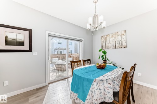 The dining area features light-colored walls, a modern chandelier, and light wood flooring - 19635 29 Avenue, Edmonton, AB - Indoor Photo Showing Dining Room