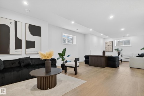 Open-concept living space featuring light wood-finish flooring, recessed lighting, and multiple windows - 711 166 Avenue, Edmonton, AB - Indoor