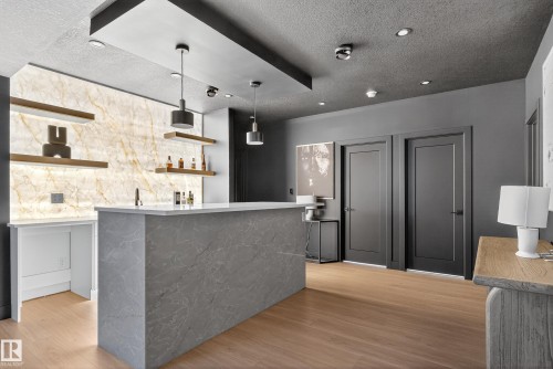 Custom bar area featuring a stone-finish countertop and a backlit stone wall - 711 166 Avenue, Edmonton, AB - Indoor Photo Showing Kitchen