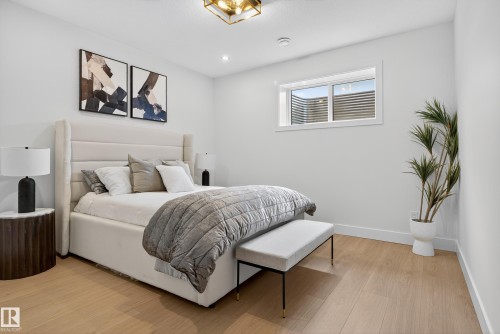 Bedroom featuring light wood-finish flooring, recessed lighting, and a white framed window - 711 166 Avenue, Edmonton, AB - Indoor Photo Showing Bedroom