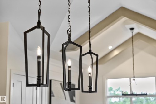 Black geometric pendant lighting fixtures with exposed candelabra bulbs - 711 166 Avenue, Edmonton, AB - Indoor Photo Showing Other Room