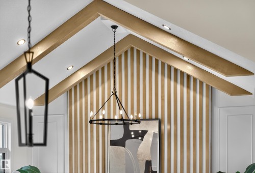 Vaulted ceiling with wood-finish beams, recessed lighting, a modern black chandelier, and a decorative slatted wall accent - 711 166 Avenue, Edmonton, AB - Indoor Photo Showing Other Room