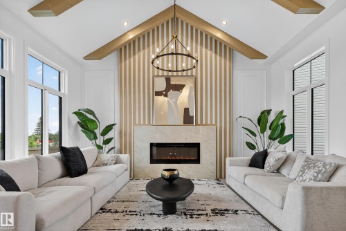 Vaulted ceiling with exposed wood-finish beams - 711 166 Avenue, Edmonton, AB - Indoor Photo Showing Living Room With Fireplace
