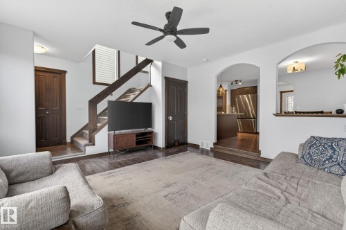 Living area featuring wood-finish flooring, a contemporary ceiling fan, and an open archway to the kitchen - 108 Hewitt Circle, Spruce Grove, AB - Indoor Photo Showing Living Room