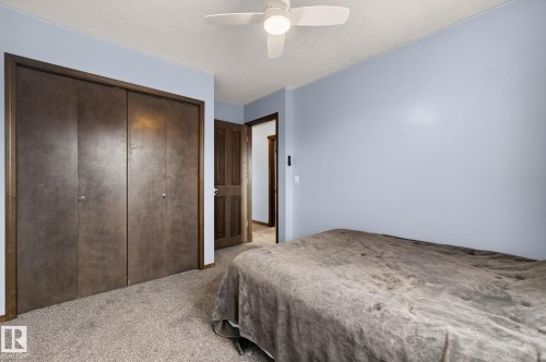 Bedroom featuring neutral carpet flooring, light blue walls, and a ceiling fan with integrated lighting - 108 Hewitt Circle, Spruce Grove, AB - Indoor Photo Showing Bedroom