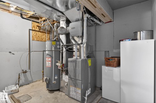 Utility area featuring a water heater, furnace, and exposed ceiling joists - 108 Hewitt Circle, Spruce Grove, AB - Indoor Photo Showing Basement