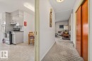 Kitchen featuring light cabinetry, a built-in wall oven, a range with an overhead exhaust. - 9732 64 Street, Edmonton, AB  - Indoor 
