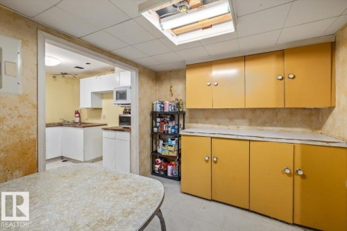 Kitchenette area featuring yellow cabinetry with circular silver hardware, light countertops, and a drop ceiling with recessed lighting - 9732 64 Street, Edmonton, AB - Indoor Photo Showing Kitchen