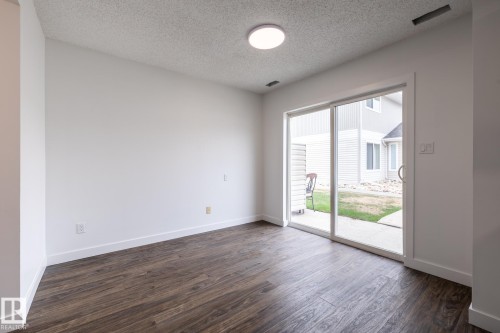 Spacious room with wood-finish flooring and a white color palette - #136, 180 Bridgeport Bv, Leduc, AB - Indoor Photo Showing Other Room