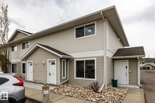 Multi-unit structure featuring two-tone siding, multiple entry doors, and gable roof accents - #136, 180 Bridgeport Bv, Leduc, AB - Outdoor With Exterior