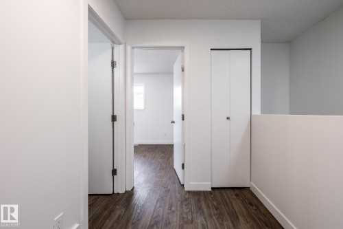 Hallway with wood-finish flooring, crisp white walls, and a recessed ceiling - #136, 180 Bridgeport Bv, Leduc, AB - Indoor Photo Showing Other Room